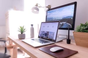Desk of a high ticket sales closer with two screens